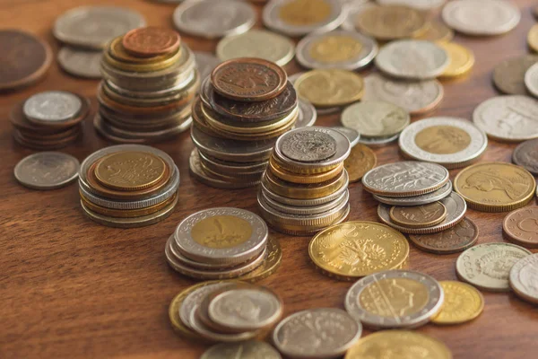 Різні золоті та срібні колекційні монети на дерев'яному тлі — стокове фото