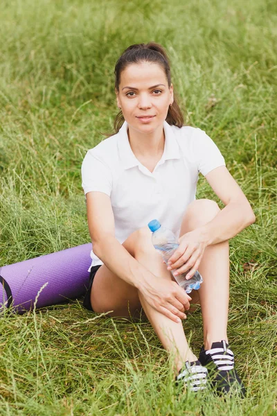 Sportovní atraktivní žena na pobřeží jezer s mat a láhev s vodou — Stock fotografie