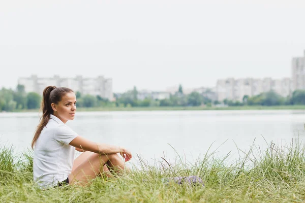 Sportovní atraktivní žena na pobřeží jezer s podložkou — Stock fotografie