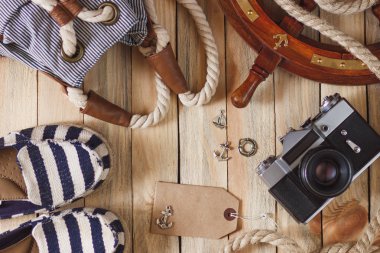 Çizgili terlik, kamera, çanta ve deniz süslemeleri, üstten görünüm