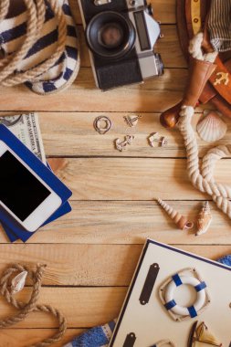 Çizgili terlik, fotoğraf makinesi, telefon ve deniz süslemeleri, üstten görünüm