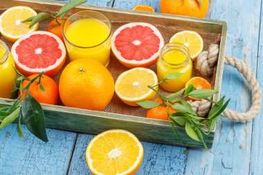 Farklı meyve ve taze portakal suyu, ahşap arka plan ile cam