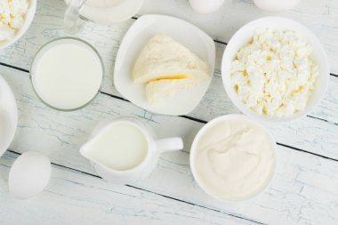 Beyaz ahşap zemin üzerinde farklı süt ürünleri