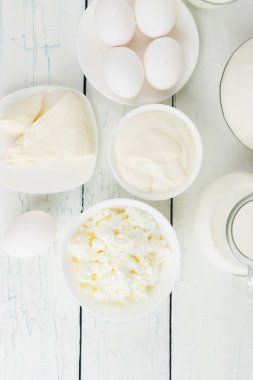 Beyaz ahşap zemin üzerinde farklı süt ürünleri