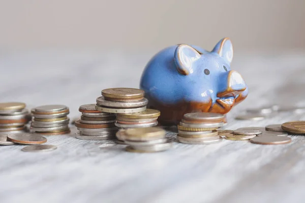 Different collector coins and piggy bank on the wooden background — Stock Photo, Image