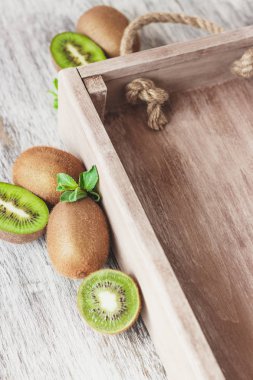 Yeşil kivi ve nane yaprakları içinde ahşap tepsi