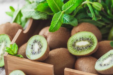 Yeşil kivi ve nane yaprakları içinde ahşap tepsi