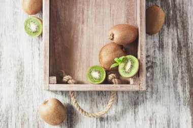 Yeşil kivi ve nane yaprakları içinde ahşap tepsi