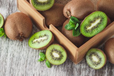 Yeşil kivi ve nane yaprakları içinde ahşap tepsi