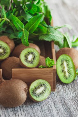 Yeşil kivi ve nane yaprakları içinde ahşap tepsi