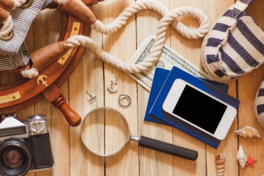 Çizgili terlik, kamera, çanta ve ahşap zemin üzerine deniz süslemeleri