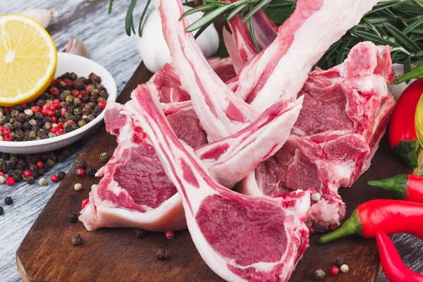 Carne cruda e ingredientes alimentarios en el tablero de madera — Foto de Stock