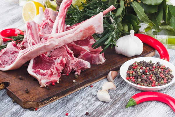 Carne cruda e ingredientes alimentarios en el tablero de madera — Foto de Stock
