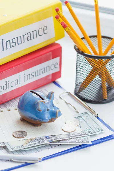 Schoon verzekeringsformulier-, piggy bank-, laptop- en geld — Stockfoto