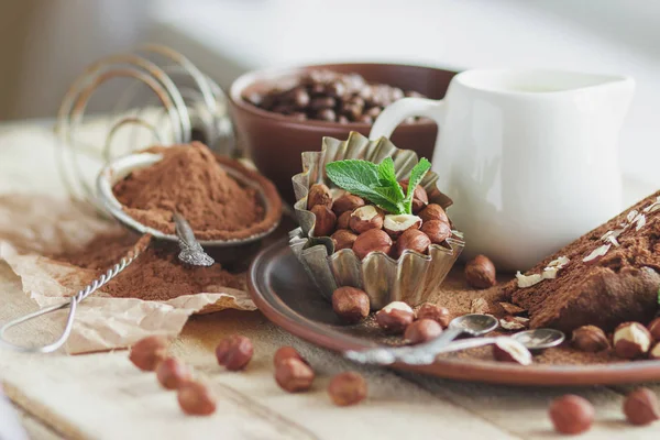 Bit chokladkaka, myntablad, hasselnötter och burk med mjölk — Stockfoto