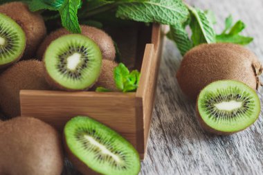 Yeşil kivi ve nane yaprakları içinde ahşap tepsi