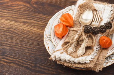 Sofra turuncu kuru çiçekler, gümüş eşyaları ve dekorasyonlar