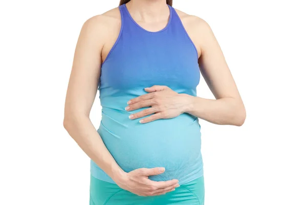 Sportowy Kobieta w ciąży z ręce na brzuchu, na białym tle — Zdjęcie stockowe