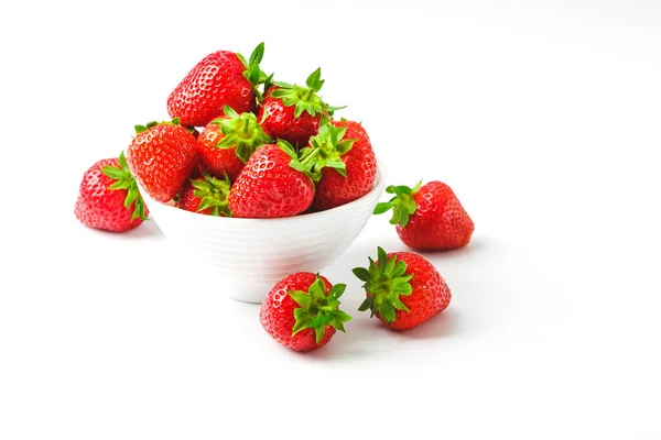 Röd mogen jordgubb i den vita skålen, ljus bakgrund — Stockfoto