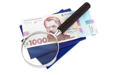 İki Ukrayna pasaportu, loupe ve bin hryvnia, izole edilmiş.