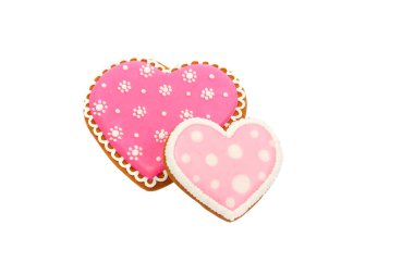 Pembe kurabiyelerin arka planında kalp farklı şekillerde, izole edilmiş.