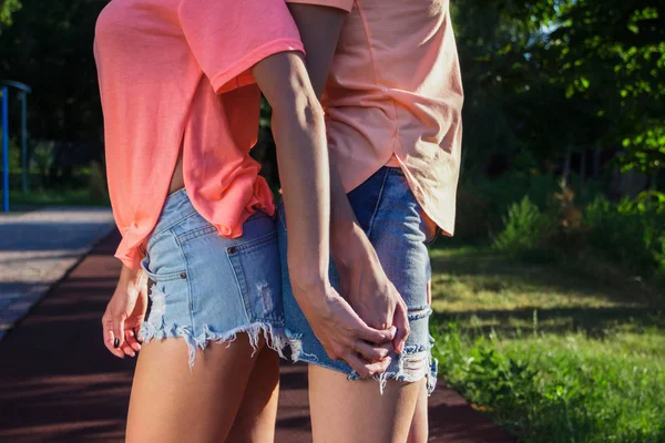 Dos hermosas chicas se abrazan, al aire libre, fondo borroso —  Fotos de Stock