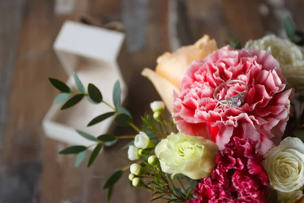 Серебряное кольцо и букет цветов, размытый фон — стоковое фото