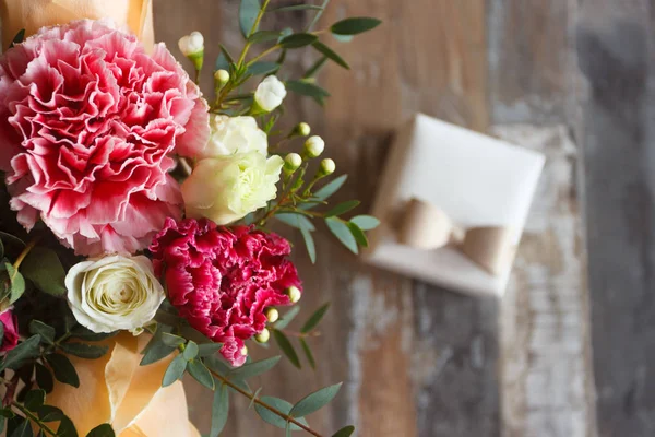 Подарочная коробка и букет цветов, размытый фон — стоковое фото
