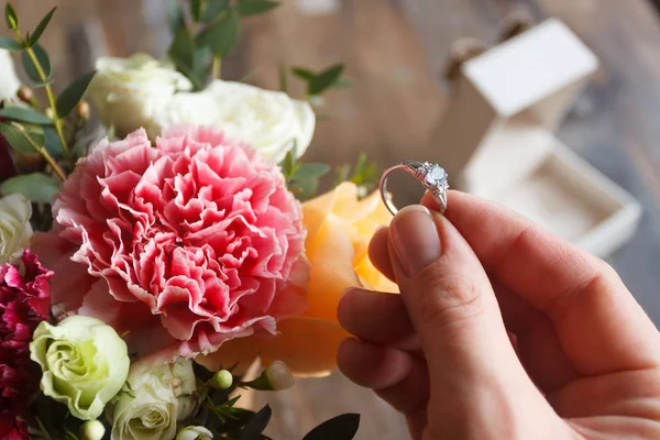 Anel de prata e um buquê de flores, fundo borrado — Fotografia de Stock