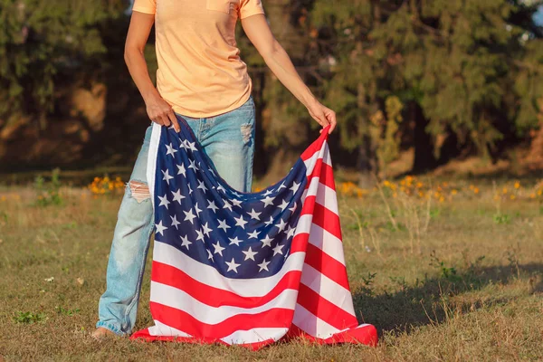 アメリカの国旗を手にした女性アウトドアソフトフォーカスの背景 — ストック写真