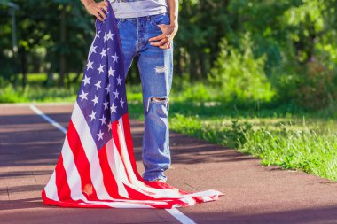 Ellerinde Amerika Birleşik Devletleri bayrağı olan bir kadın, açık havada, yumuşak odaklı arka planda