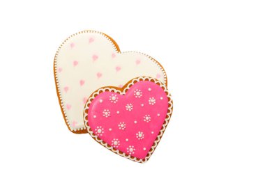 Pembe kurabiyelerin arka planında kalp farklı şekillerde, beyaz renkte izole edilmiş.