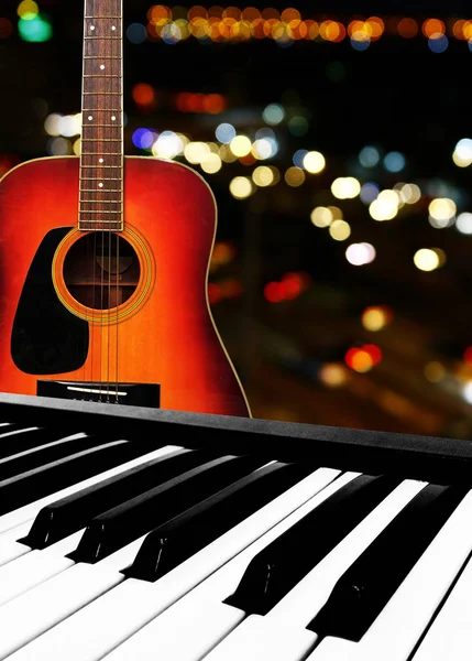 Electronic Piano Keyboard and Guitar on bokeh background.