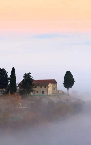 Toscaanse landschap met landhuizen en cipressen in de herfst mist — Stockfoto