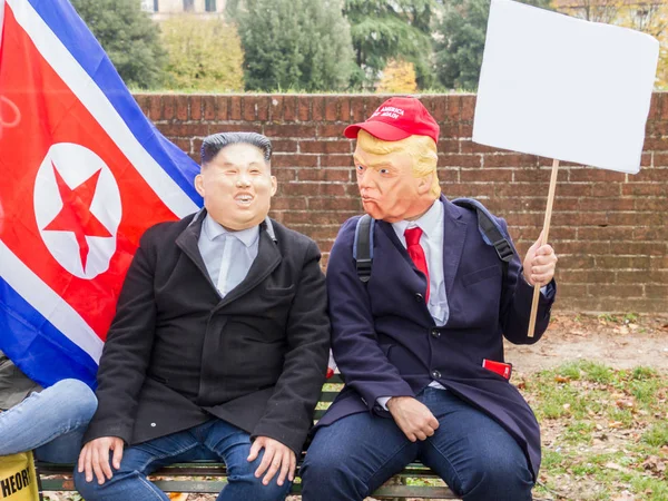 Два человека в масках Дональда Трампа и Ким Чен Ына ведут себя дружелюбно — стоковое фото