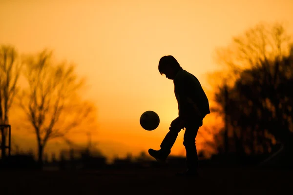 Petit joueur de football en soirée — Photo