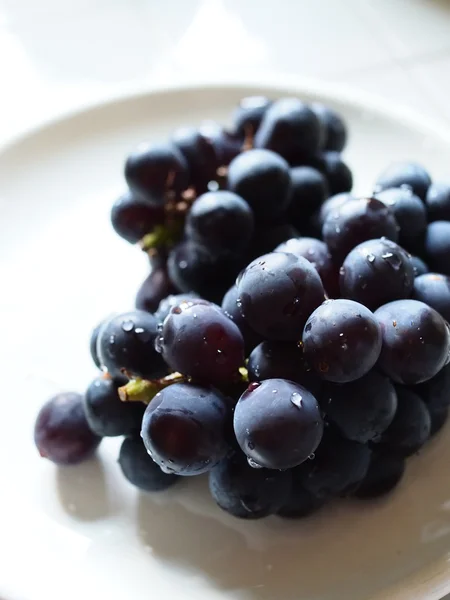 Uva fresca no prato branco — Fotografia de Stock