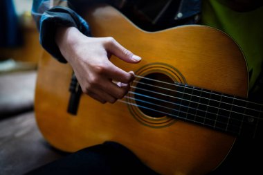 Odada gitar çalıyor.