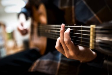 Odada gitar çalıyor.