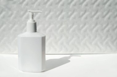 Alkol bazlı bir virüse karşı beyaz bir arka planda bir şişe antiseptik jel, gölge düşürme; metin için bir yer var.