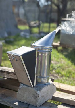 Arıdaki metal dumanı arıları korkutup kaçırıyor. Sıcak ve dumanlı bir tuğlada duruyor