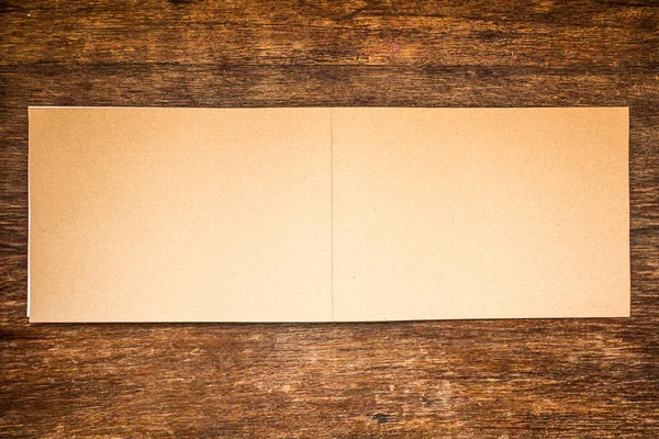 Empty Old beige grained paper for painting on old grungy dark brown wooden table background close up. Soft focus