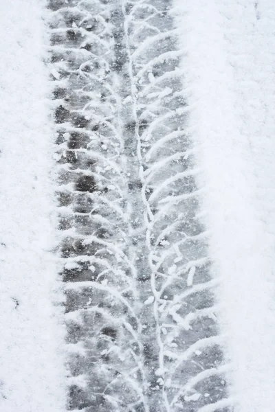 stock image Wheel tracks on the winter road covered with snow.