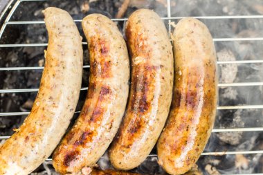 Bir Barbekü otlar ile beyaz sosis ızgara