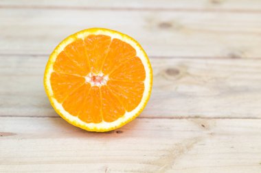 Kompozisyon olgun taze portakal ahşap arka plan üzerinde kesti. Exot