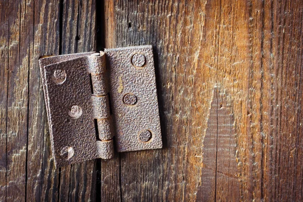 Bisagra oxidada rota vieja con pernos sobre un fondo de madera —  Fotos de Stock