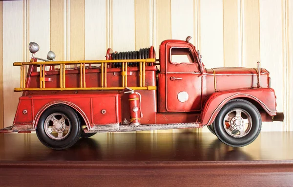 Camión de bomberos rojo: modelo de coche clásico sobre papel pintado pelado marrón — Foto de Stock