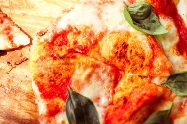 Dilim peynir ve baharat ile pizza ve fesleğen yaprakları kapatmak 