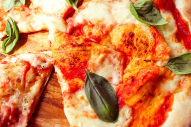 Dilim peynir ve baharat ile pizza ve fesleğen yaprakları kapatmak 