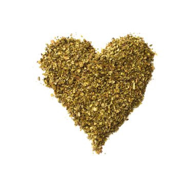 Dökülen kuru majoram yığın üzerinde beyaz backg izole kalp yapılmış